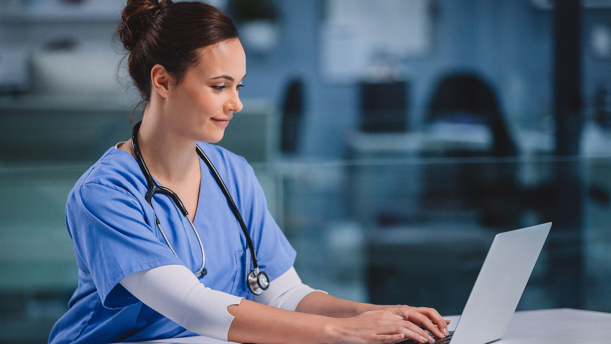 Healthcare professional using a laptop.