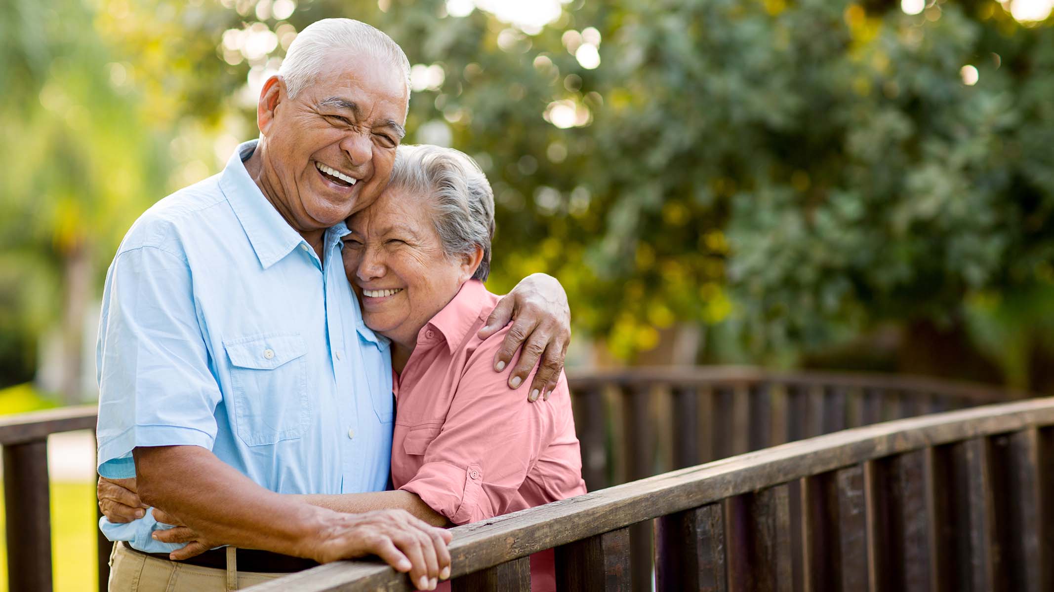 Senior couple in park hugging