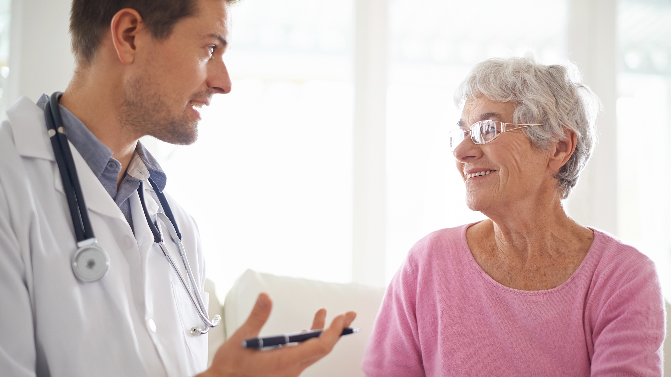 Médico explicando algo a su paciente de la tercera edad.