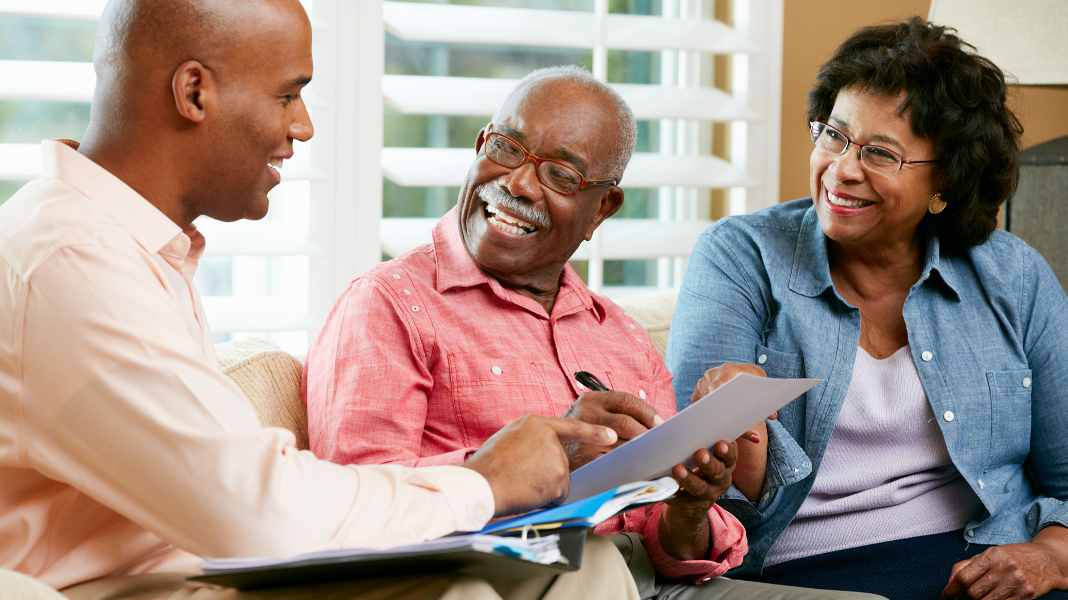 Senior couple smiling at agent.