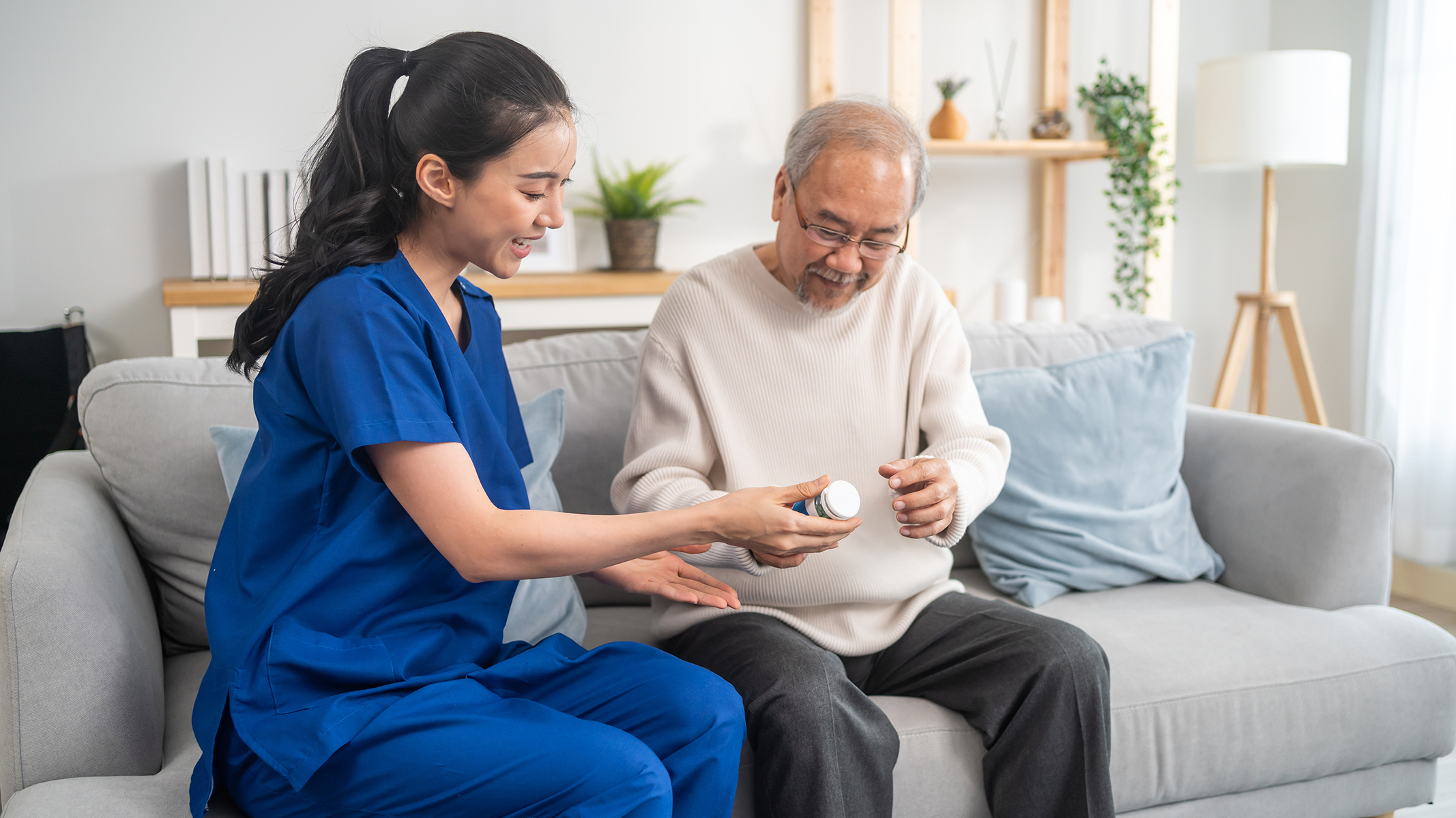 Senior man with female healthcare provider holding prescription.