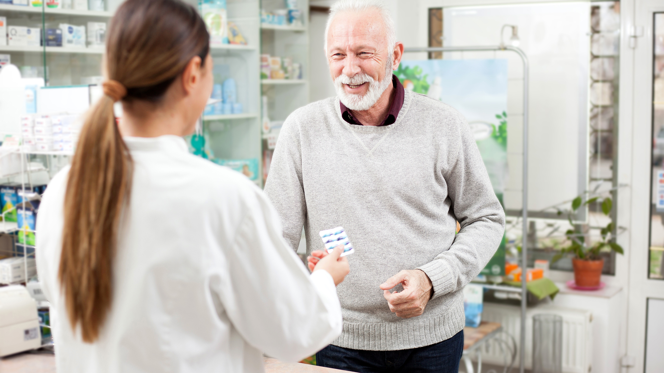 Hombre mayor comprando medicamentos en una farmacia.