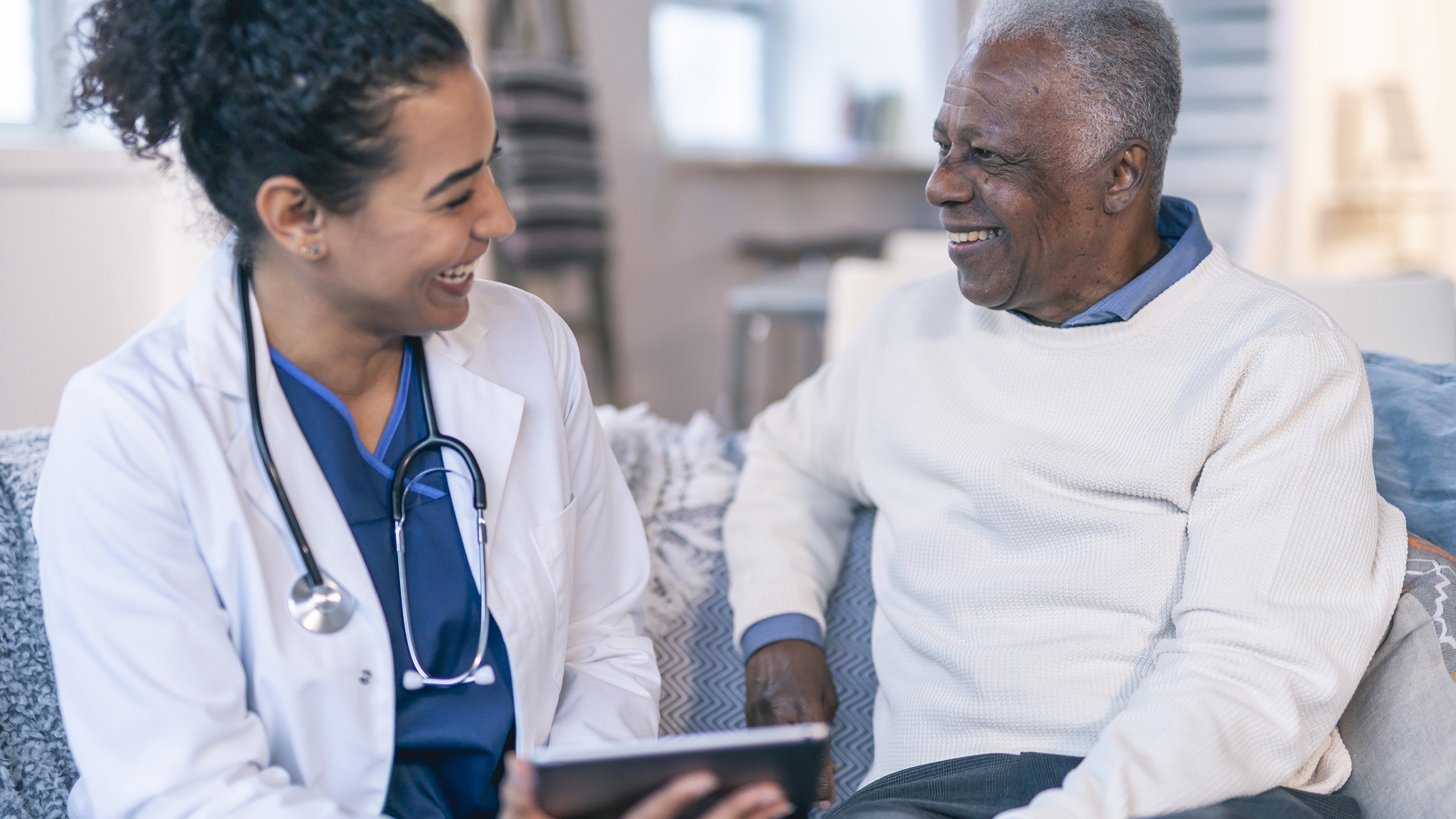 Female doctor speaking with senior man.