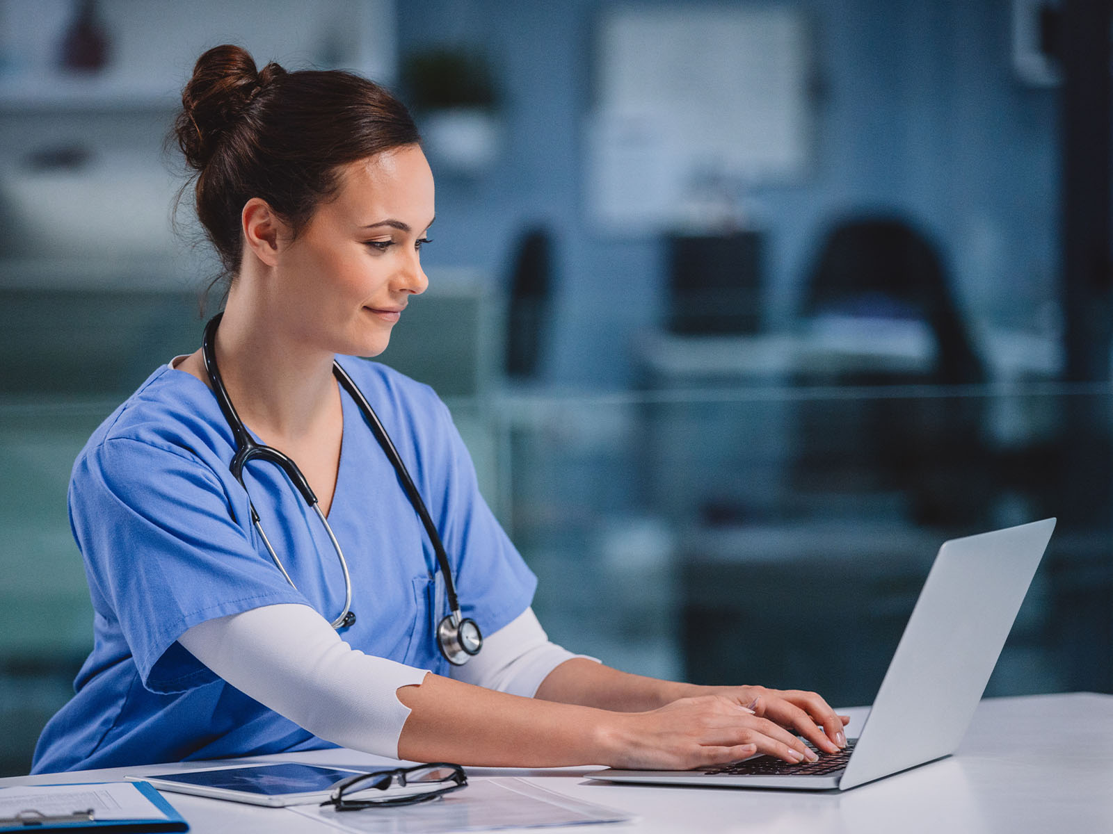 Healthcare professional using a laptop. 