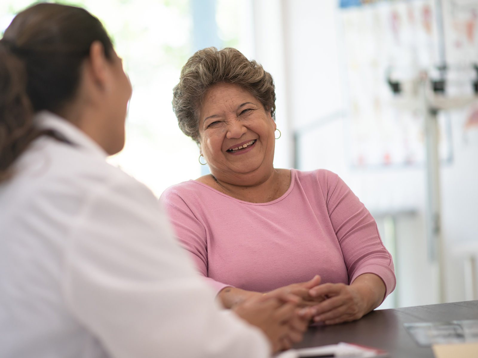 Older woman speaking with female doctor. 