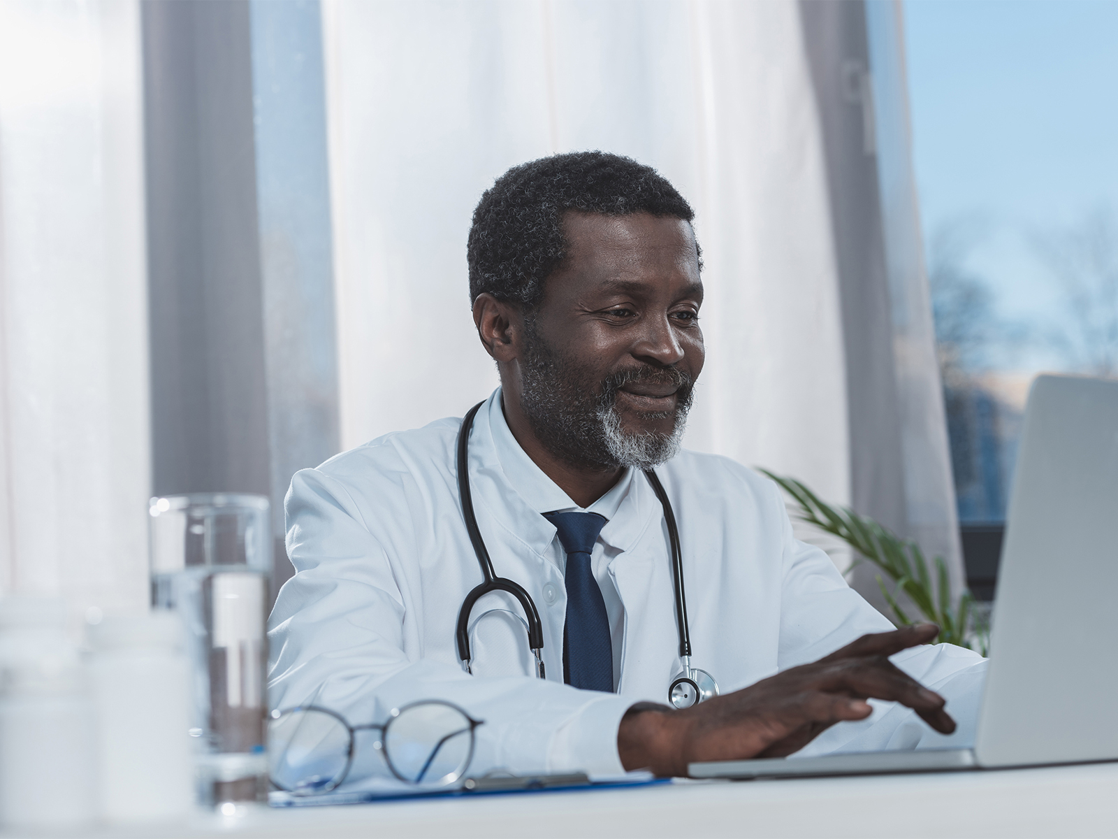 Male doctor using laptop.