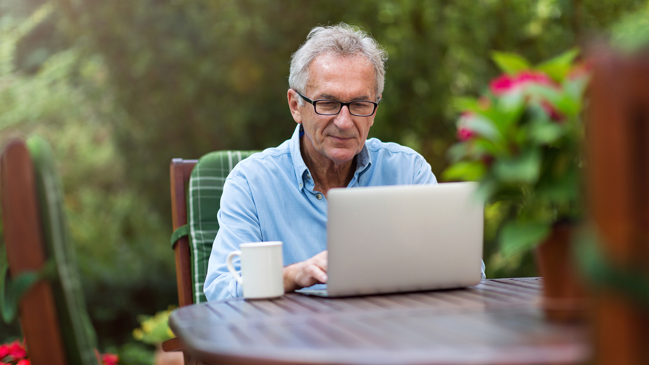 Hombre mayor trabajando con una laptop al aire libre