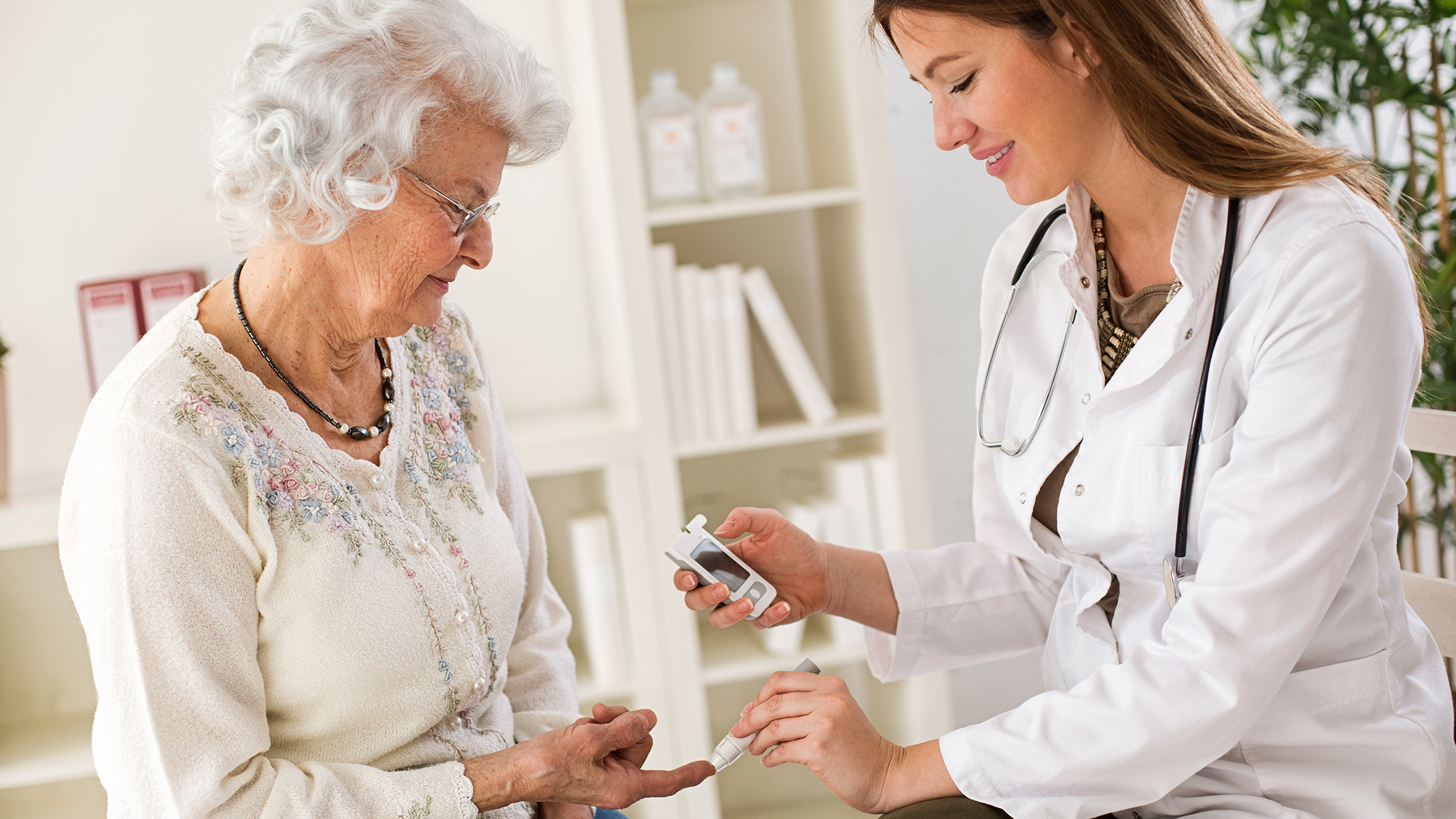 Senior woman getting her glucose tested by a healthcare professional