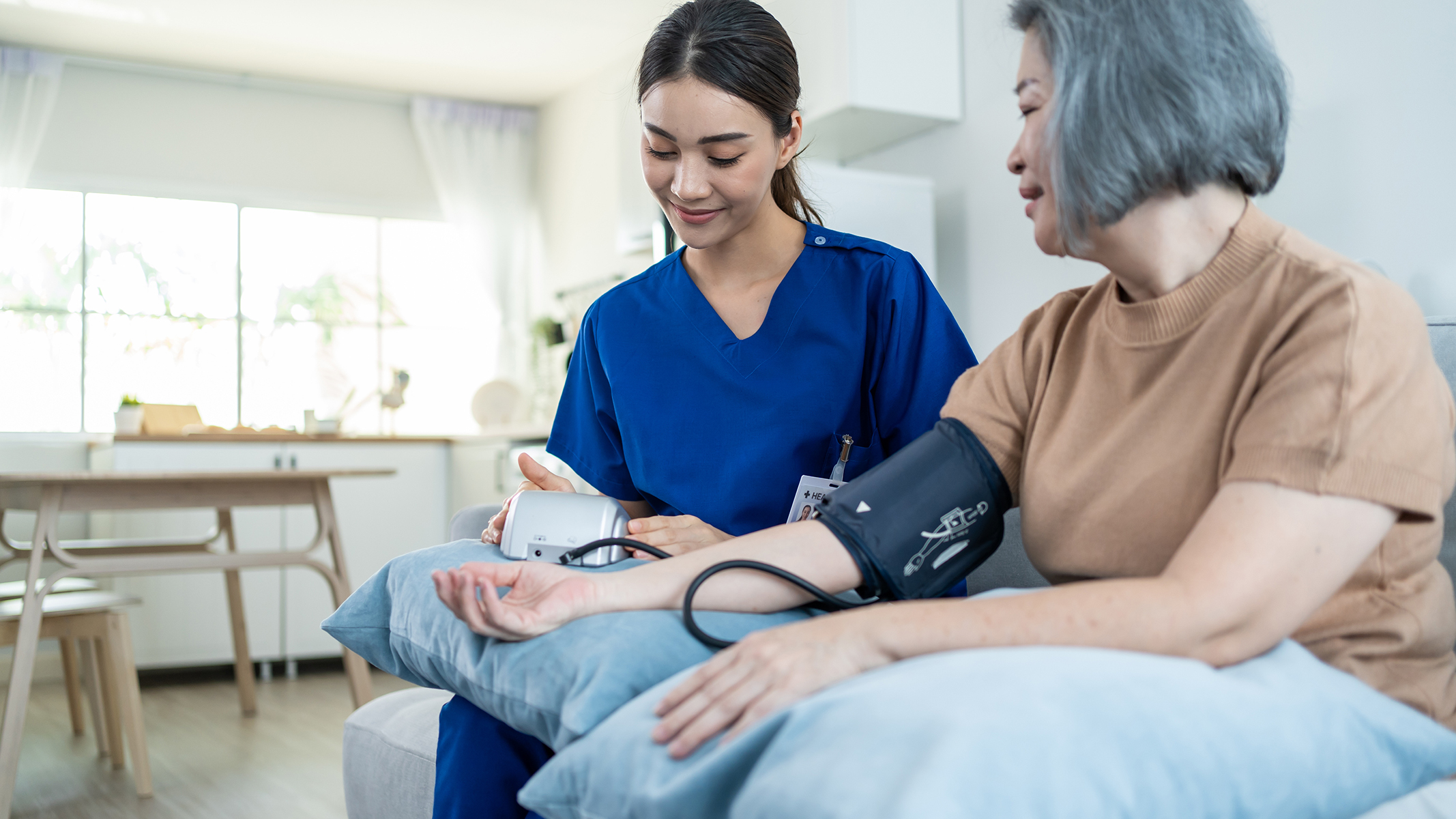 Senior woman getting her blood pressure measured by a healthcare professional