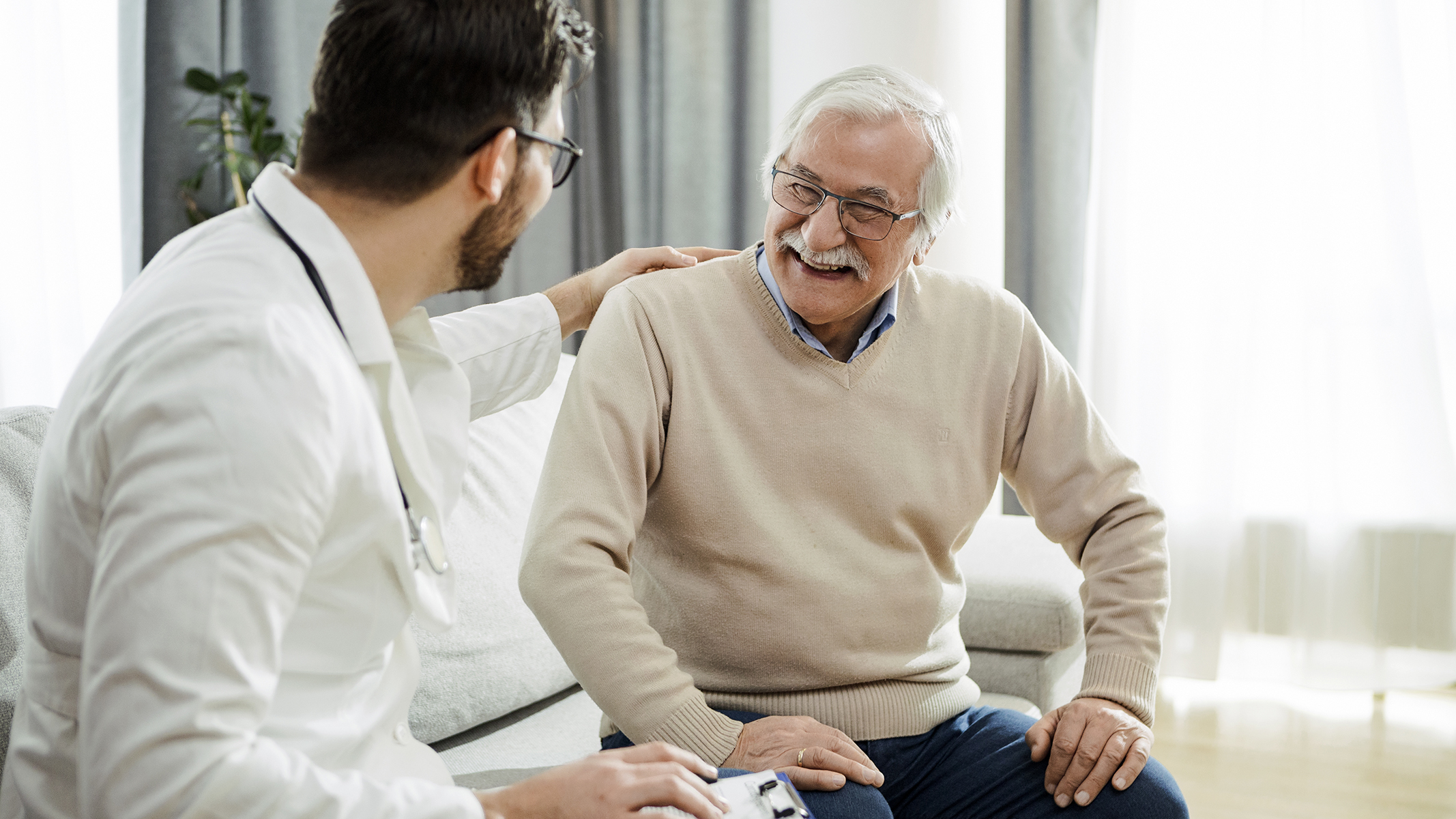 Hombre mayor sonriendo con un médico