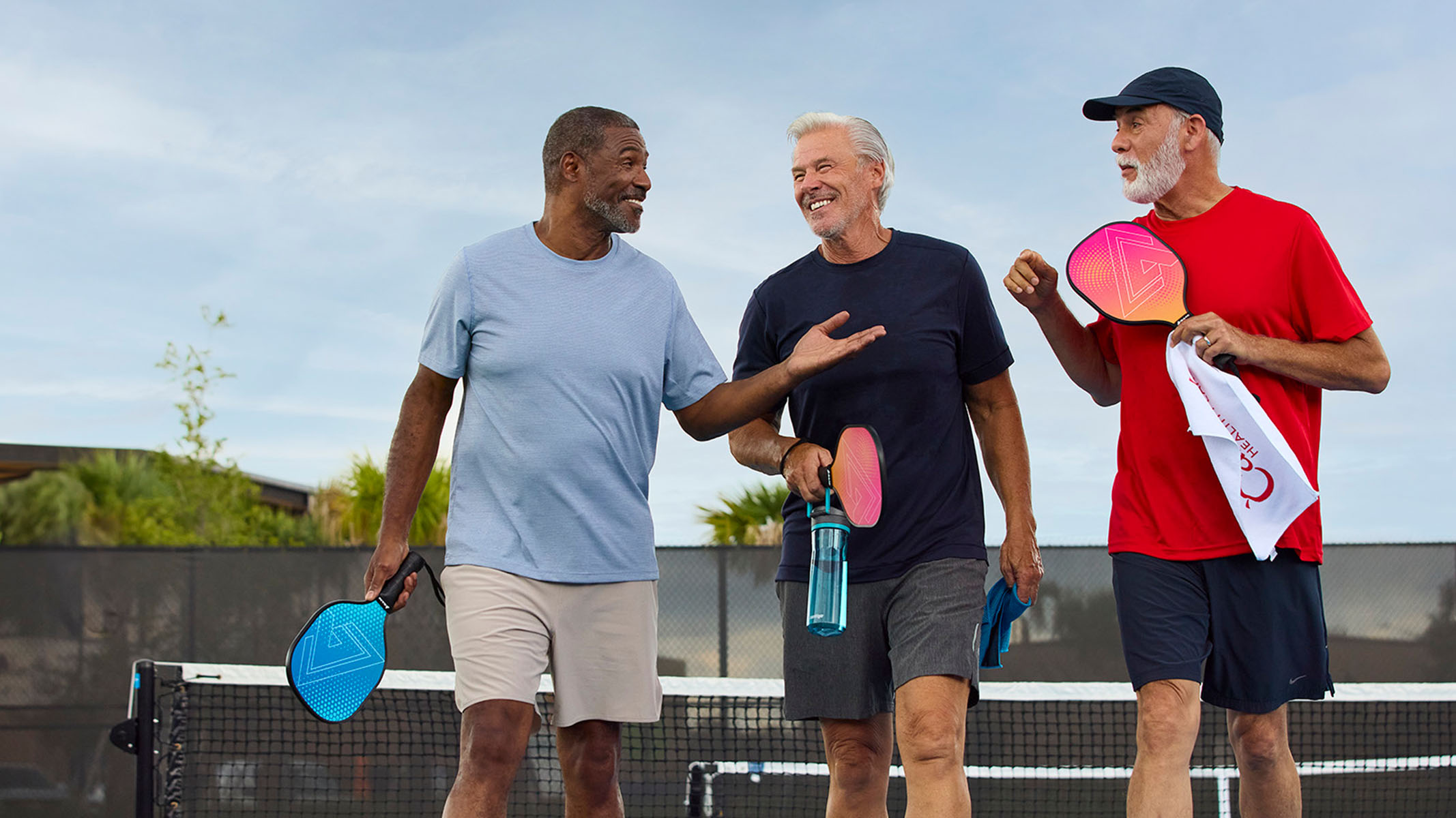 Group of senior men talking together after a game of pickleball.