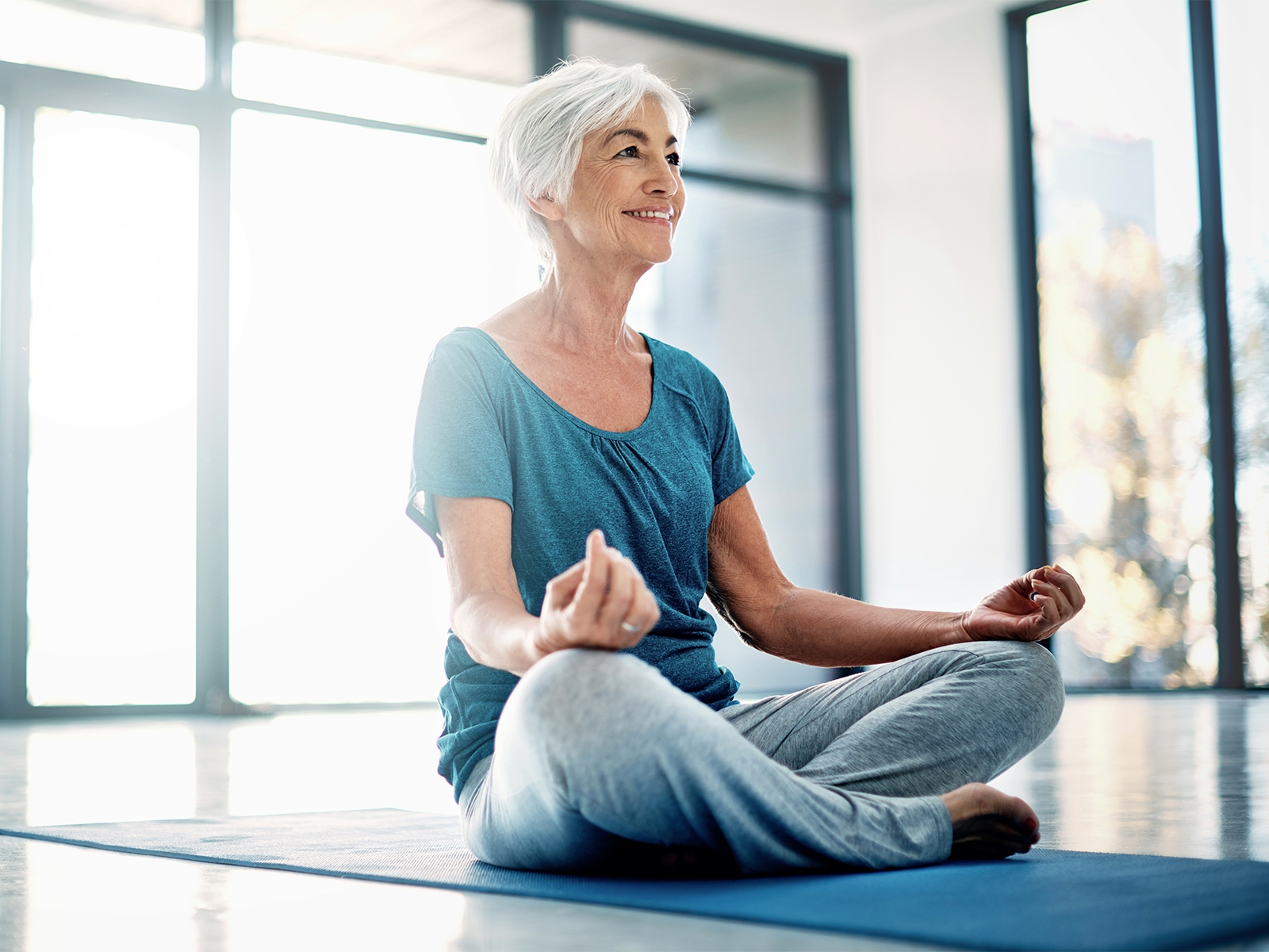 mujer mayor haciendo yoga en interiores