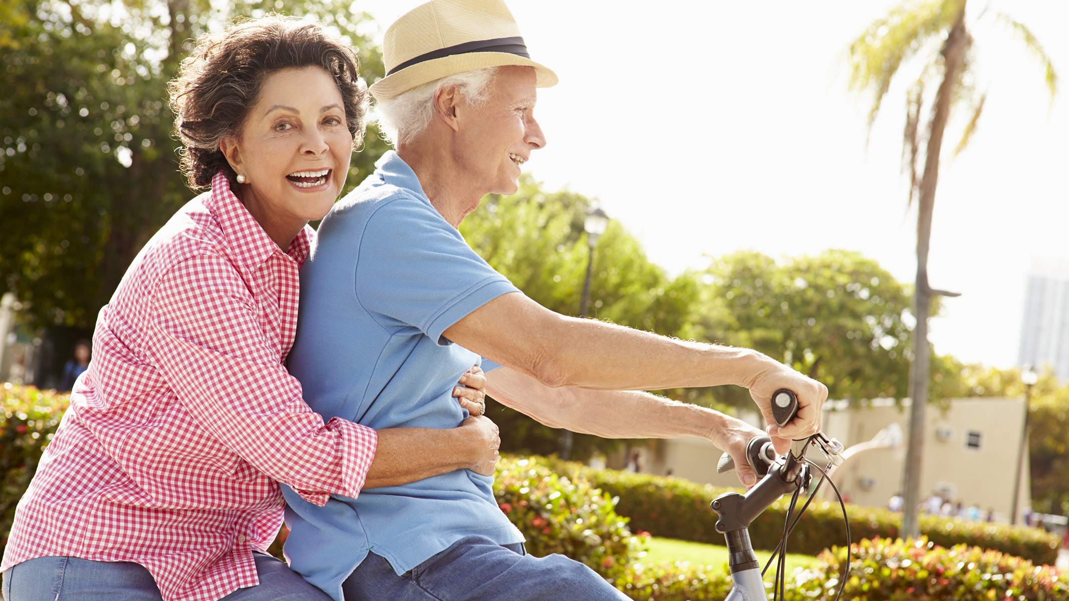 Pareja de personas mayores andando en bicicleta.