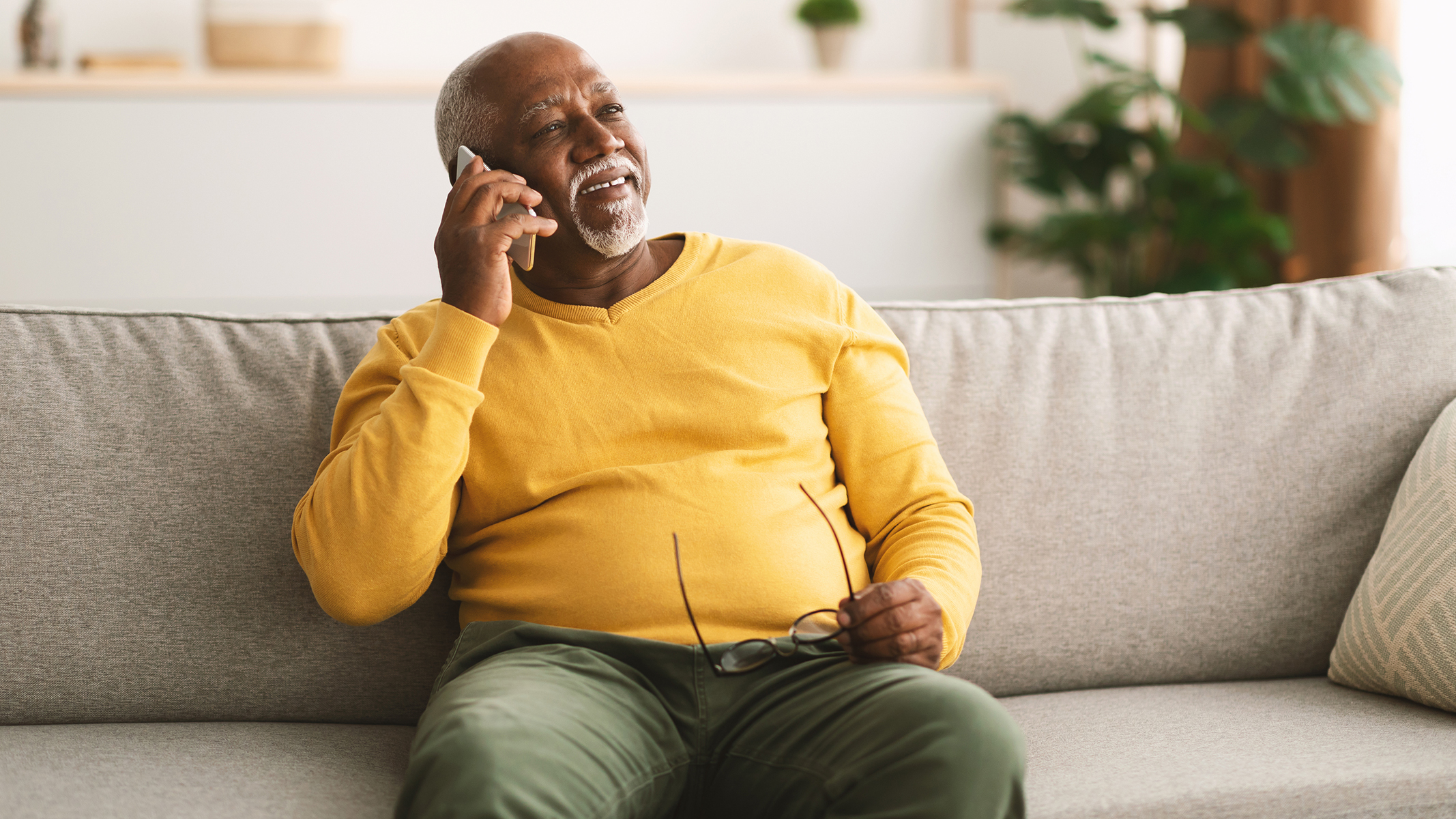 Senior sitting on sofa talking on the phone.