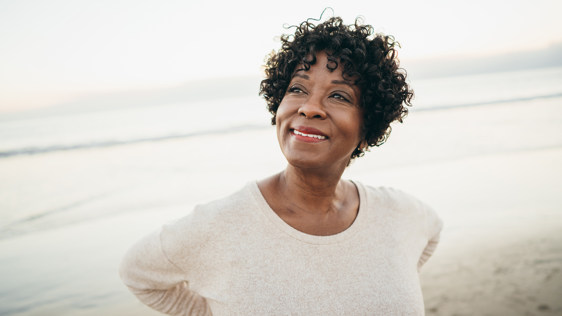 Mujer sonriendo en la playa.