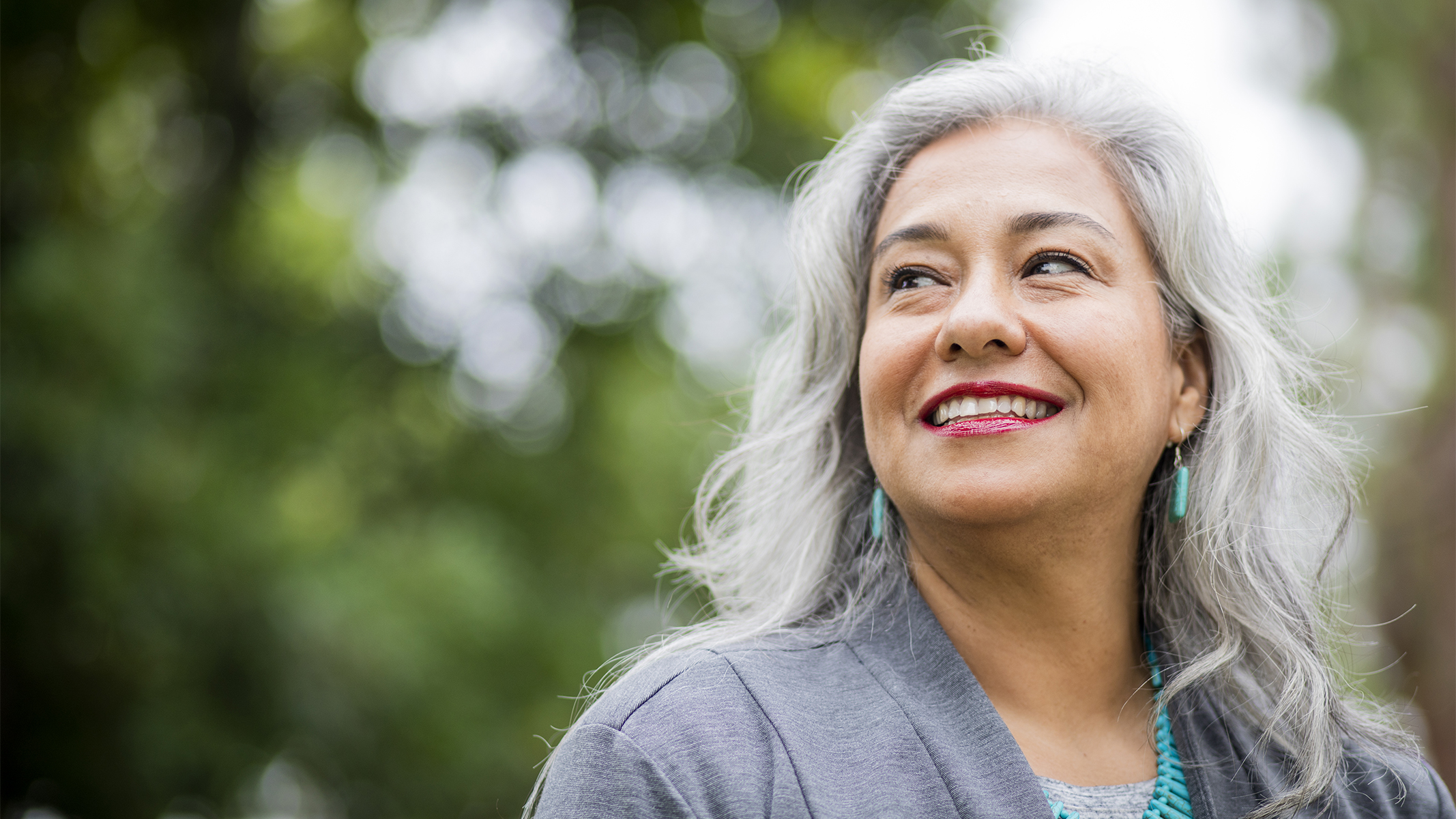 Senior woman smiling outside.