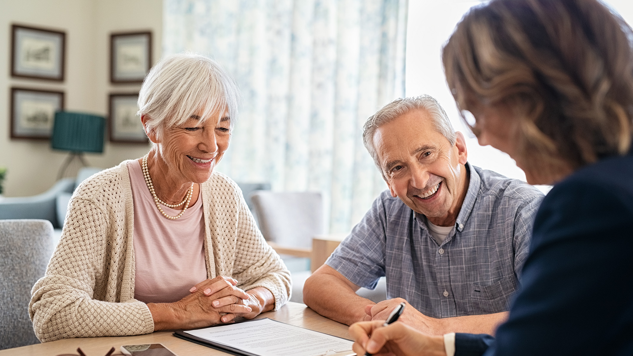 Agent talking to a senior couple in their home.