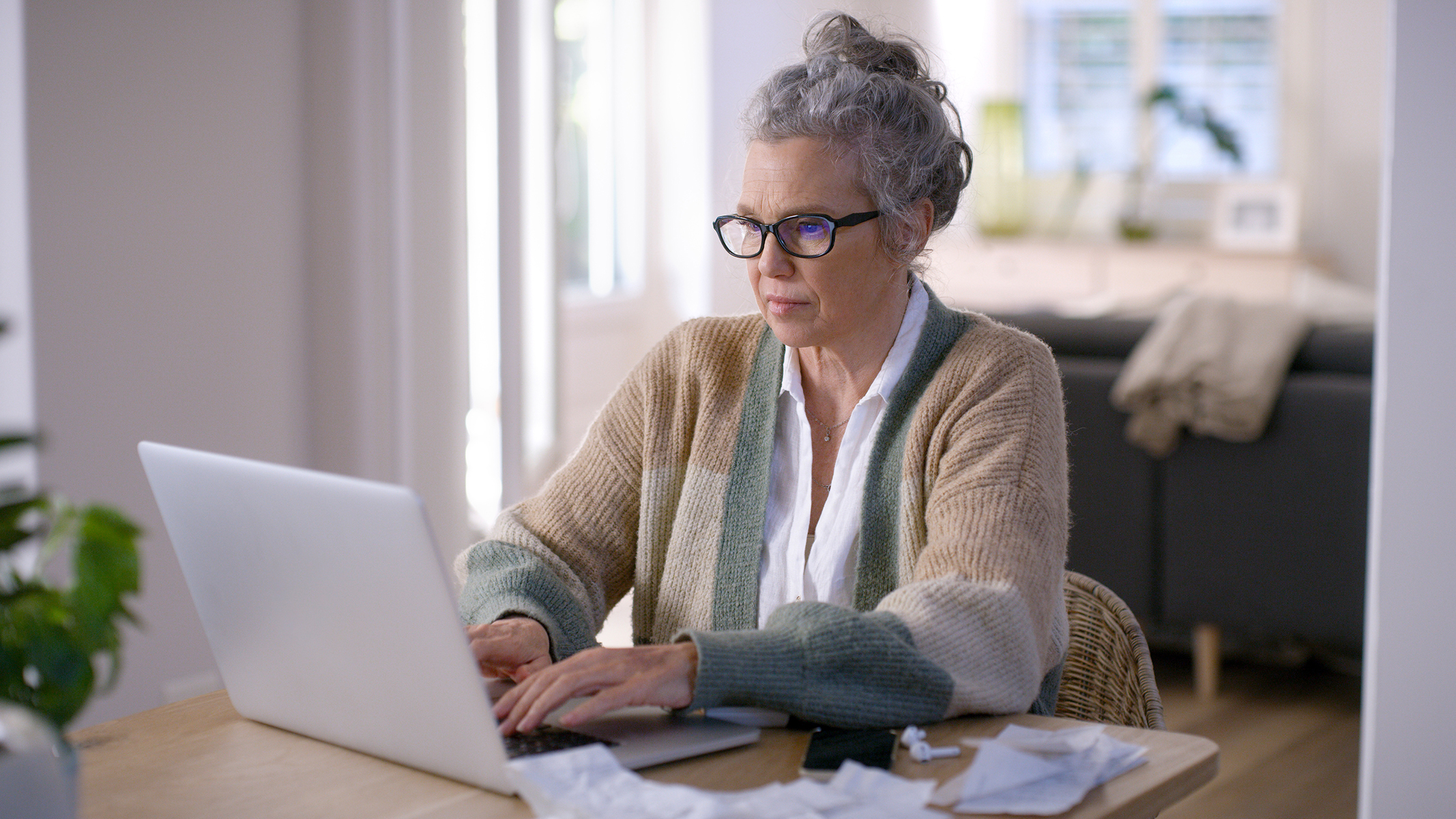 Senior woman working on a laptop while sitting at a table