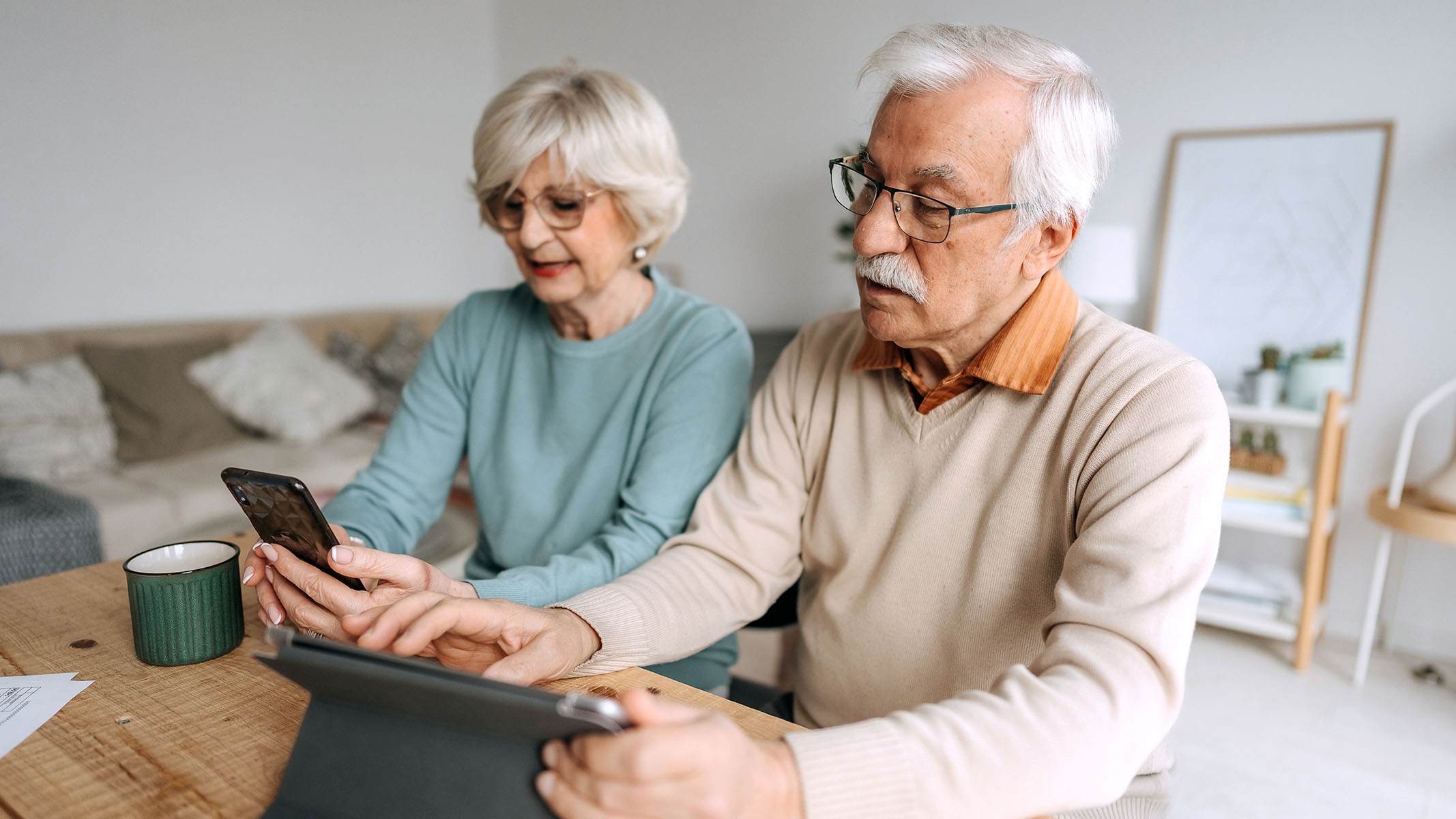 Senior couple using a mobile phone and tablet.